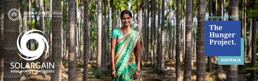 Girl in green sari standing in forrest symbolising partnership with Solargain, Solar Dwellings and The Hunger Project.
